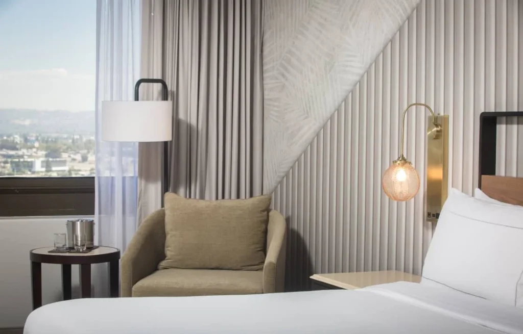 close-up of bed and chair inside of hotel room