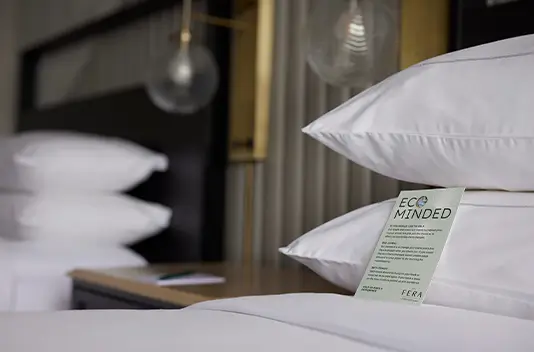 eco sign on bed at hotel fera