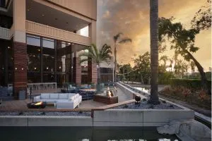 An outdoor lounge with a fire pit at sunset